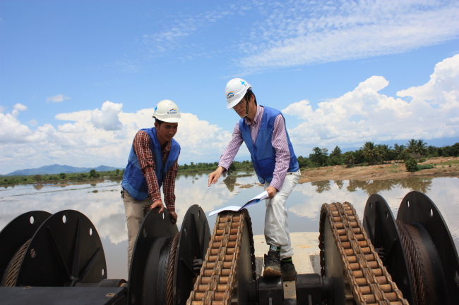 Two K-water employees check a dam in Krang Ponley, Cambodia. (K-water)