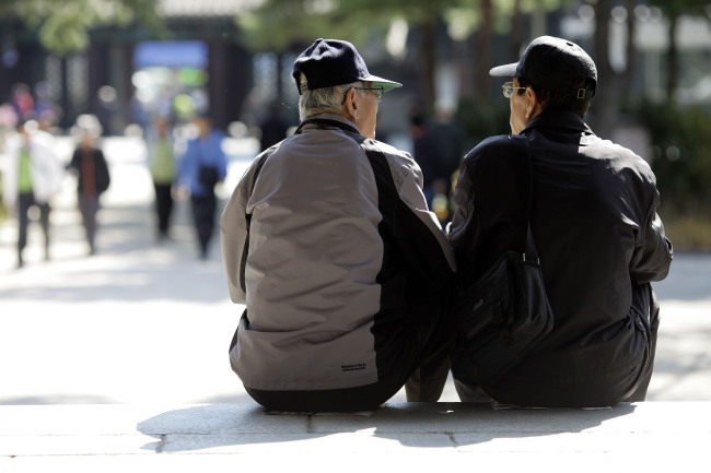 Elderly men sit on steps at Tapgol Park in Jongno district, Seoul. (Bloomberg)