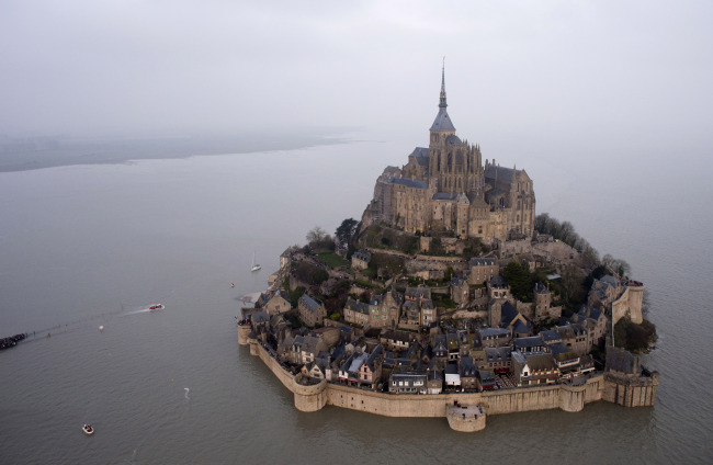 An aerial view as a high tide submerges a narrow causeway leading to the Mont Saint-Michel, on France`s northern coast, Saturday. AP