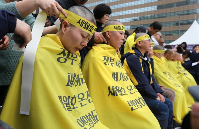 Relatives of the victims of the Sewol ferry disaster shave their heads in Gwanghwamun Square in downtown Seoul, Thursday. (Yonhap)