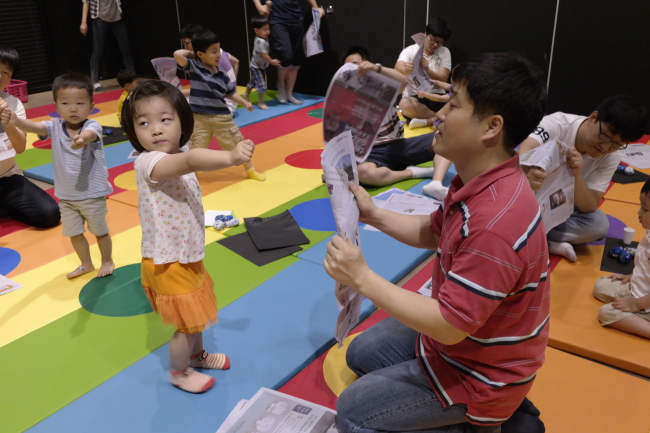 A father and his daugther tear newspapers as part of Seoul City’s program for dads and children at City Hall in Seoul. (Seoul Metropolitan Government)