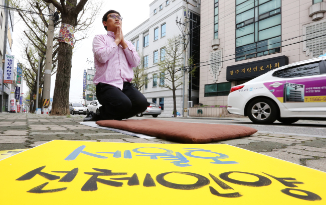 A citizen bows in respect to the 304 lost lives from the Sewol ferry sinking in April last year in front of the Gwangju High Court on Tuesday. A final trial on appeal was due at the court on the captain and crew of the ship, who have been convicted of negligence. (Yonhap)