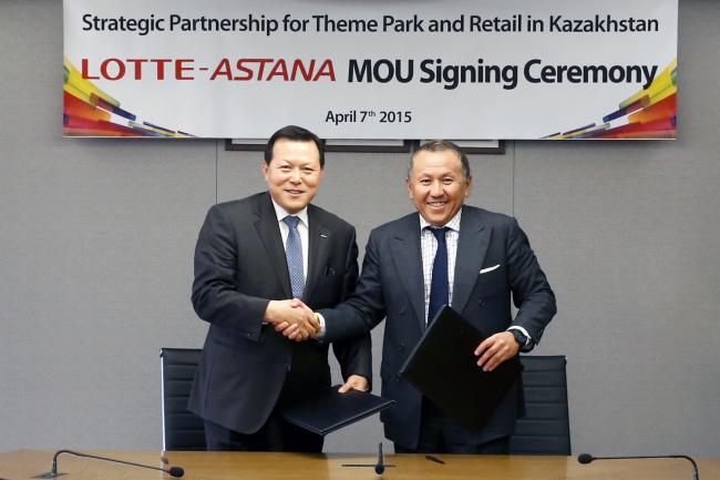 Lotte Corp. president Hwang Kak-gyu (left) shakes hands with Astana Group president Nurlan Smagulov during an MOU signing ceremony in Seoul on Wednesday. (Lotte Group)