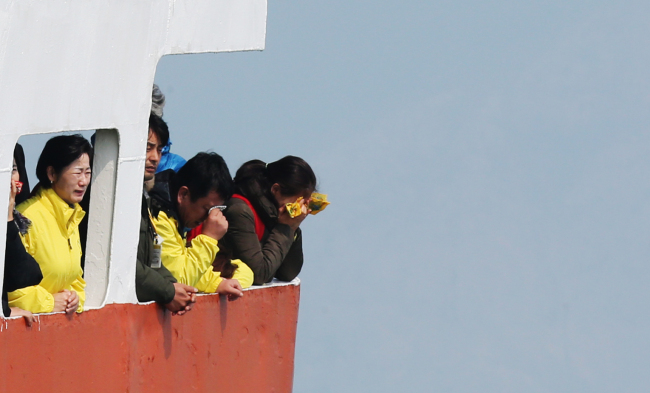Families of Sewol disaster victims weep as they offer flowers to the waters off Jindo, South Jeolla Province, Wednesday. (Yonhap)