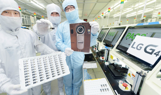 LG Innotek workers pose with a sheet of 16-megapixel camera modules, which will be used in LG Electronics’ new marquee smartphone G4. (LG Electronics)