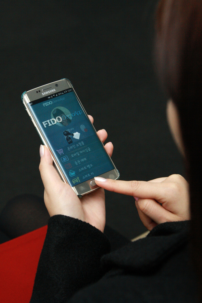 A woman uses the Samsung SDS’ biometric identification with Samsung Electronics’ Galaxy S6 Edge on Monday. (Samsung SDS)