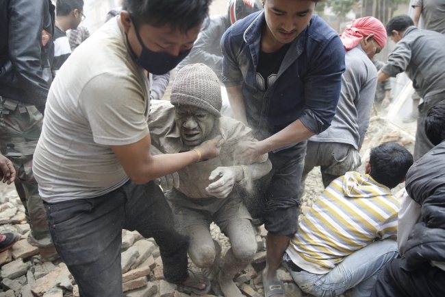 People free a man from the rubble of a destroyed building after an earthquake hit Nepal, in Kathmandu, Nepal, 25 April 2015. A 7.9-magnitude earthquake rocked Nepal destroying buildings in Kathmandu and surrounding areas, with unconfirmed rumours of casualties. The epicentre was 80 kilometres north-west of Kathmandu, United States Geological Survey. Strong tremors were also felt in large areas of northern and eastern India and Bangladesh (EPA-Yonhap)