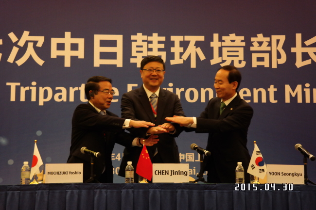 From right: The environment ministers of South Korea, China and Japan, Yoon Seong-kyu, Chen Jining and Mochizuki Yoshio, join hands after signing the Tripartite Joint Action Plan at the 17th Tripartite Environment Ministers Meeting in Shanghai on Thursday. (Environment Ministry)
