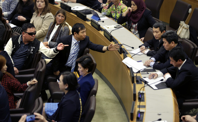 North Korean defectors, left, argue with North Korean diplomats, right, at United Nations headquarters, April 30, as the diplomats attempt to make a statement during a panel on North Korean human rights abuses. (AP)
