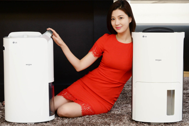 A model poses with LG Electronics’ new Whisen dehumidifiers that boast a 17-liter inverter ― the largest capacity within the industry ― at a launch event in Seoul on Monday. (LG Electronics)