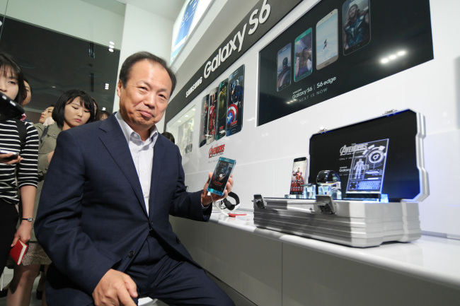 Samsung Electronics’ mobile business chief Shin Jong-kyun poses with some of the tech giant’s devices featured in the movie “Avengers: Age of Ultron,” at Coex in southern Seoul on Monday. (Samsung Electronics)