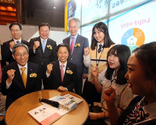 KB’S GOOD JOBS ― KB Financial Group chairman Yoon Jong-kyoo (first from left, front row) and Education Vice Minister Kim Jae-choon (second from left, front row) pose with students during their participation in a two-day KB Good Job Exhibition at Coex on Wednesday, which invited 250 selected companies and job seekers. (KB)