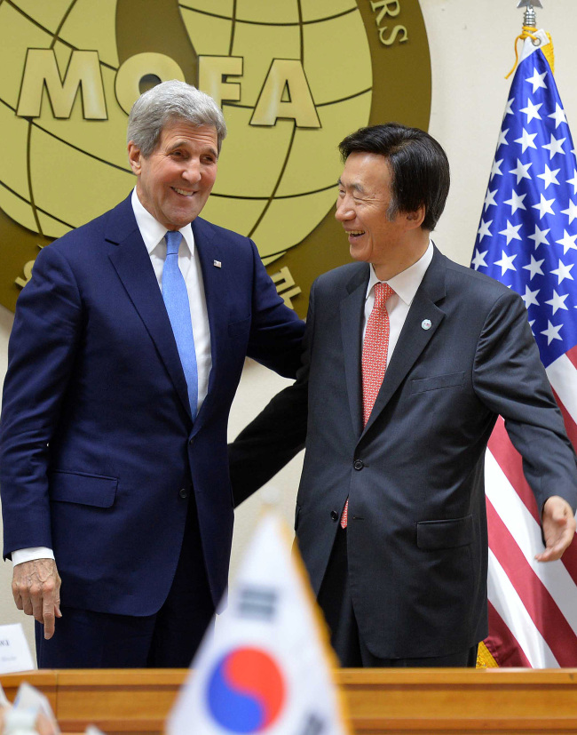 Foreign Minister Yun Byung-se (right) poses with U.S. Secretary of State John Kerry at the Foreign Ministry building in central Seoul on Monday. (Yonhap)