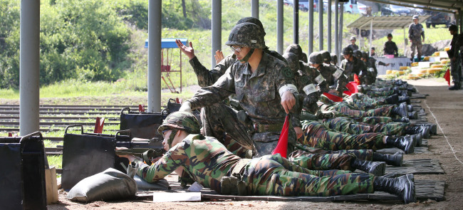 Reservists participate in shooting drills under the guidance of instructors in the 73rd Army division in Namyangju, Gyeonggi Province, on May 20. The military introduced one-on-one assistance throughout the exercise in the wake of a fatal shooting incident earlier this month. (Yonhap)