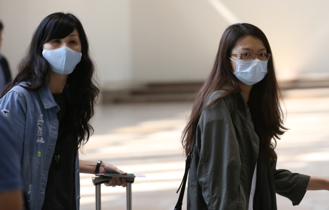 Tourists enter Korea wearing masks through Gimpo International Airport after the government confirmed the seventh case of MERS on Thursday. (Yonhap)