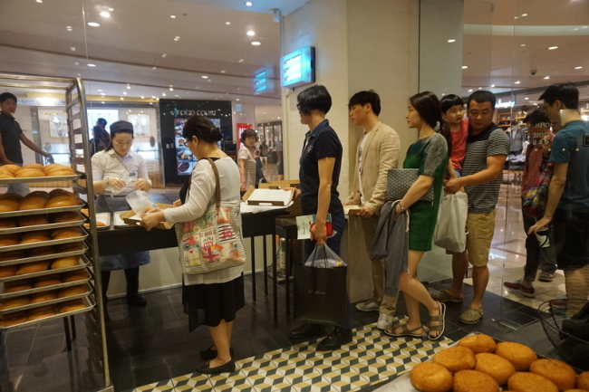 Customers line up to buy sweet red bean buns and vegetable buns at Lee Sung Dang Bakery’s Jamsil branch in southern Seoul. (Ahn Sung-mi/The Korea Herald)