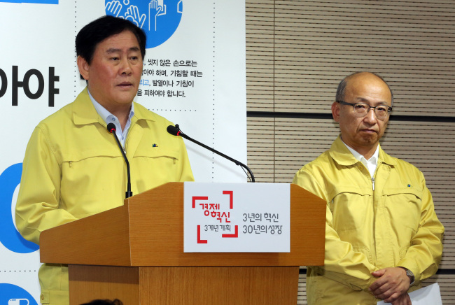 Finance Minister Choi Kyung-hwan (left) makes a public announcement on MERS in Sejong City on Wednesday as Health Minister Moon Hyung-pyo looks on. (Yonhap)