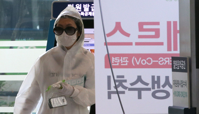 A woman wearing a mask, plastic gloves and a raincoat enters Samsung Medical Center, one of the most heavily MERS-affected hospitals, in Ilwon-dong, southern Seoul, Wednesday. (Yonhap)