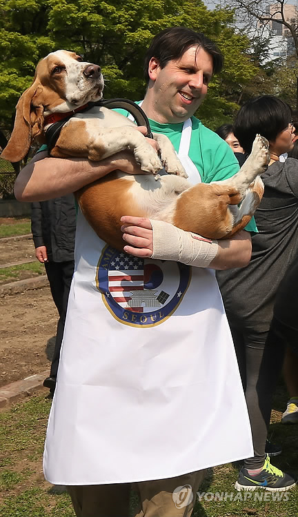 U.S. Ambassador Mark Lippert holds his dog Grigsby at an outdoor event at his residence in Seoul on April 22. (Yonhap)