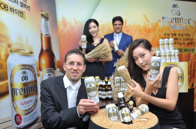 Brew master Stefan Muller (left) and Oriental Brewery CEO Frederico Freire (second from right) present Premier OB Weizen at a launching event in Seoul on Wednesday. (Oriental Brewery)