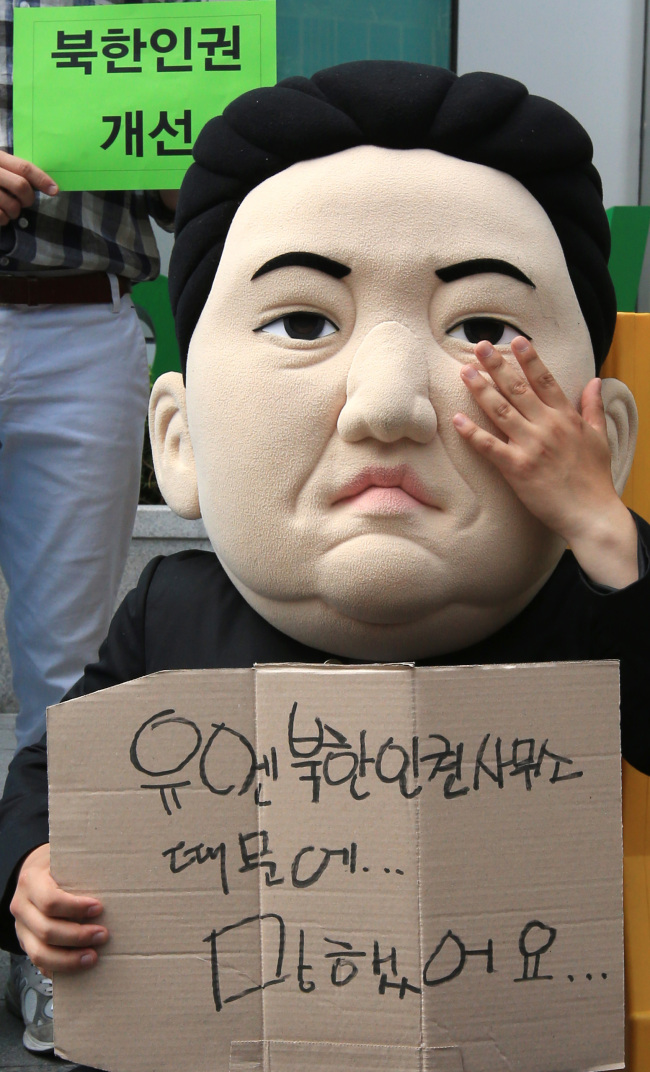 A member of a college student group for North Korean human rights wears a mask that looks like North Korean leader Kim Jong-un during a rally in front of the U.N. field office to monitor the communist state’s human rights situation in Seoul on Tuesday. (Yonhap)