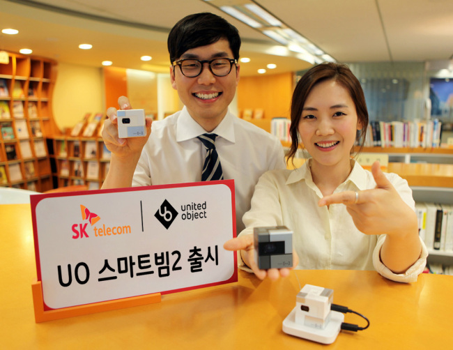 BRING CINEMA EXPERIENCE HOME — South Korea’s leading mobile carrier SK Telecom rolls out a new pico projector, UO Smart Beam 2 on Monday. The portable device featuring 80 lumens of brightness can display an image size of up to 110 inches from a distance of 3 meters. SKT