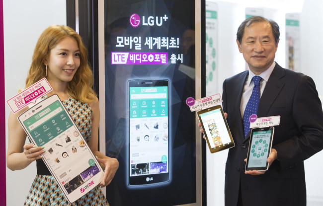 WATCH VIDEO CONTENT ON SINGLE PLATFORM -- LG Uplus chief executive Lee Sang-chul (right) and singer BoA pose at a launch ceremony of the mobile carrier’s mobile video portal service running on the Long Term Evolution networks. LG Uplus subscribers can watch live TV shows, movies, videos on demand and user-created content on their smartphones via the portal.  LG Uplus