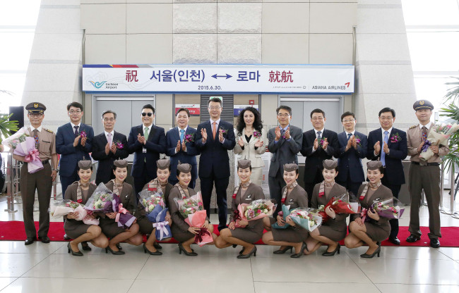 Asiana Airlines CEO Kim Soo-cheon (sixth from left) poses with Tiziana Di Molfetta (seventh from left), councilor at the Italian Embassy in Korea, and Asiana‘s cabin attendants during a ribbon-cutting ceremony to celebrate the airline‘s launch of an Incheon-Rome route at the departure hall of Incheon International Airport, Tuesday. (Asiana Airlines)