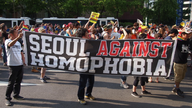 LGBT rights activists march forward holding a banner that read 