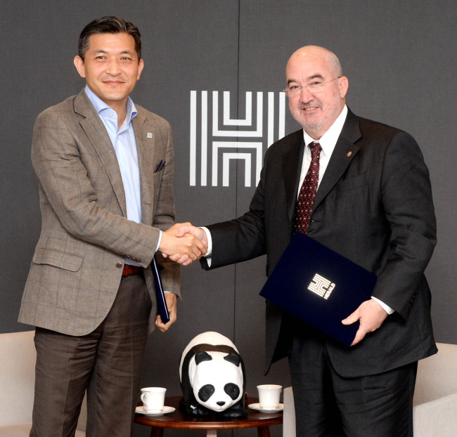 Chairman Jungwook Hong (left) of Herald Corp. shakes hands with World Wide Fund for Nature Korea Cochairman Jean-Paul Paddack after singing an MOU at Herald Square in Yongsan, Seoul, Thursday. Between the two chairmen is a panda figurine, an emblem of the “1600 Pandas World Tour” that started in 2008 as a collaboration between WWF and French artist Paulo Grangeon, now displayed in Jamsil, Seoul. Park Hyun-koo/The Korea Herald