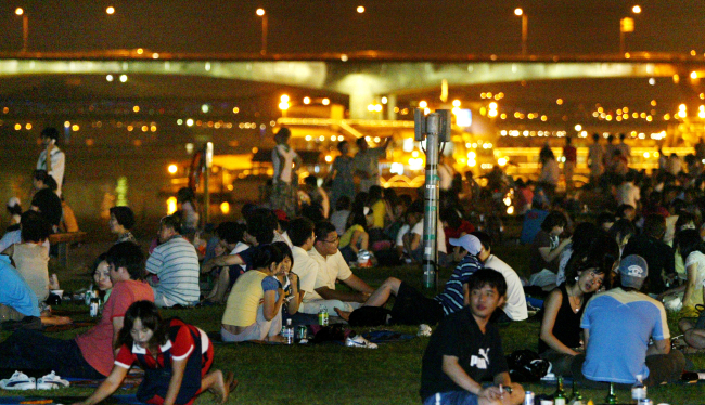 Picnickers brave the summer heat at a riverside park in Seoul. (The Korea Herald file photo)