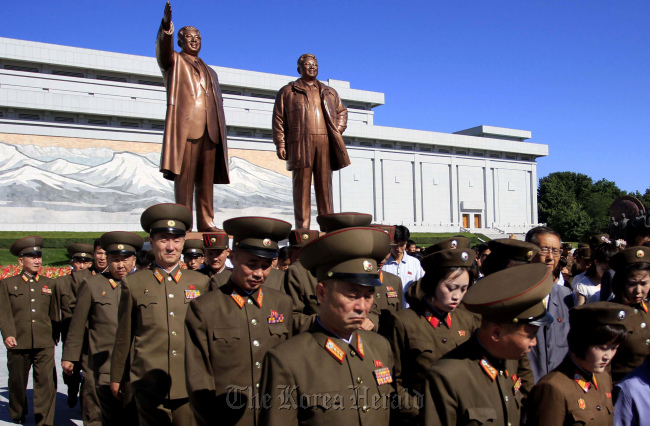 North Korean soldiers leave after paying their respects to their late leader Kim Il-sung to mark the 21st anniversary of his death at Mansu Hill where a bronze statue of him and his son, Kim Jong-il stands, Wednesday, July 8. (AP-Yonhap)