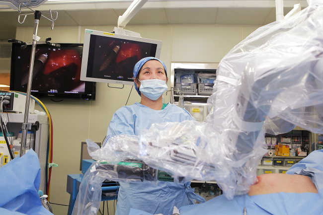 Dr. Moon Hye-sung (center) performs single-site robotic surgery. (Ewha Womans University Mokdong Hospital)
