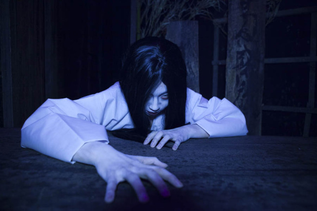 An actor dressed up as a “gwisin,” a traditional Korean specter with long hair and a bloody, white gown (Culture Mine)