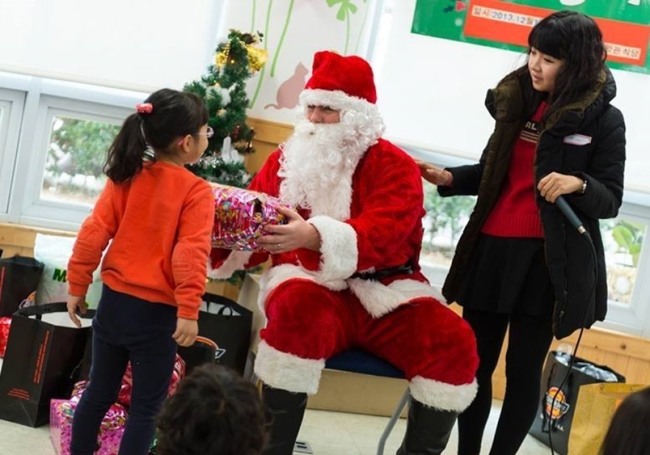 Santa gives out gifts as part of a previous Adopt a Child for Christmas – Gwangju event. (Relja Kojic)