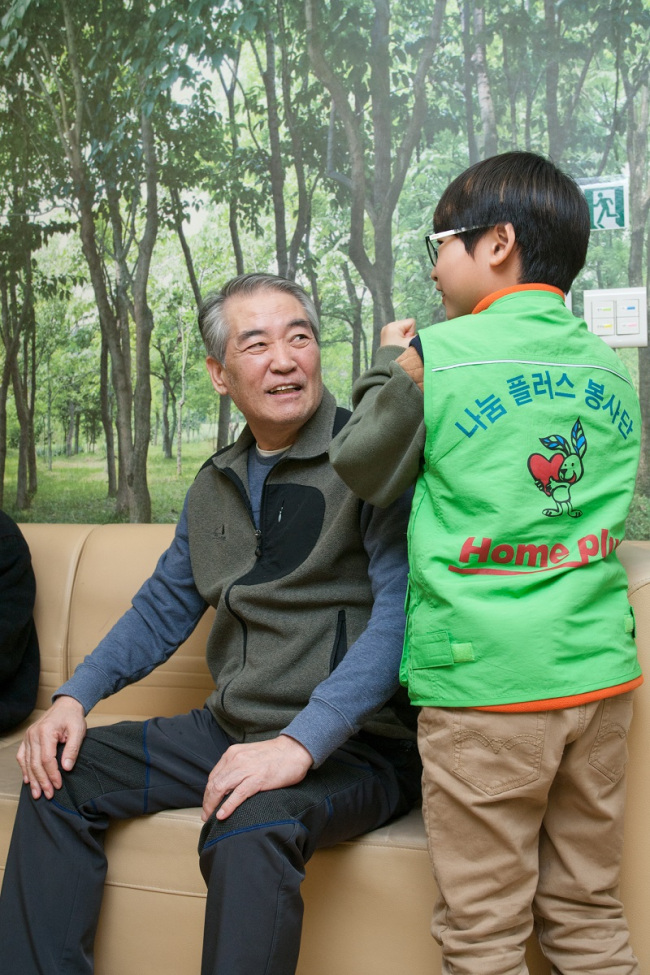 A “Sharing Plus Community Service” participant massages an elderly’s shoulders. (Homeplus)