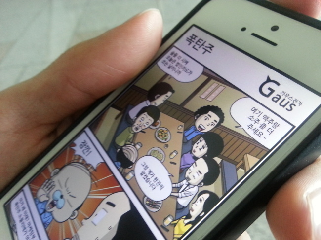 A cut from a webtoon is displayed on a smartphone. Sohn ji-young/The Korea Herald