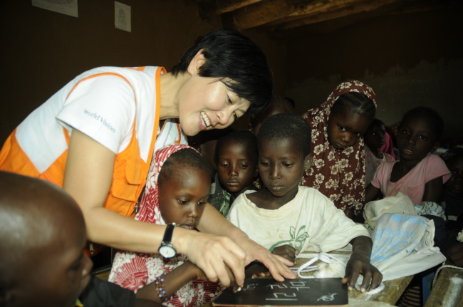 Han shows how to write “Mali” in Korean to children during her humanitarian mission in the West African country in 2013.