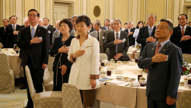 President Park Geun-hye, Korea Liberation Association chairman Park Yu-chul (right) and other participants pledge allegiance to the national flag during a luncheon event to appreciate some of the country’s former independence fighters and their bereaved families at Cheong Wa Dae on Wednesday. (Yonhap)
