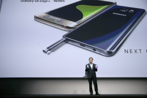 JK Shin, president and CEO of Samsung Electronics holds the Samsung Galaxy S6 Edge+ (left) and the Samsung Galaxy Note 5 during a presentation, Thursday at Lincoln Center in New York. (AP-Yonhap)