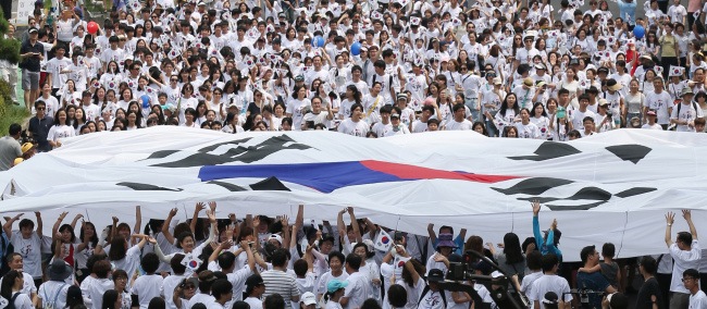 About 2,000 participants hold up a giant national flag, Taegeukgi, as part of the flash mob event to mark the 70th anniversary of Korea’s Liberation Day at Olympic Park in eastern Seoul, Saturday. Yonhap