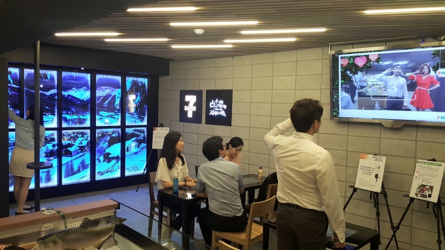 Customers try out an augmented reality system at 7-Eleven’s “Creative Economy store” in Myeong-dong, Seoul.(Korea Seven)