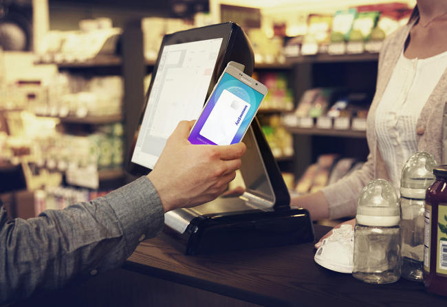 A customer pays with Samsung Pay at a grocery. Samsung Electronics