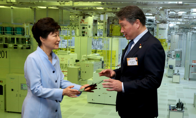 President Park Geun-hye (left) and SK Group chairman Chey Tae-won talk at SK hynix`s new chip plant in Icheon, Gyeonggi Province, Tuesday. Yonhap
