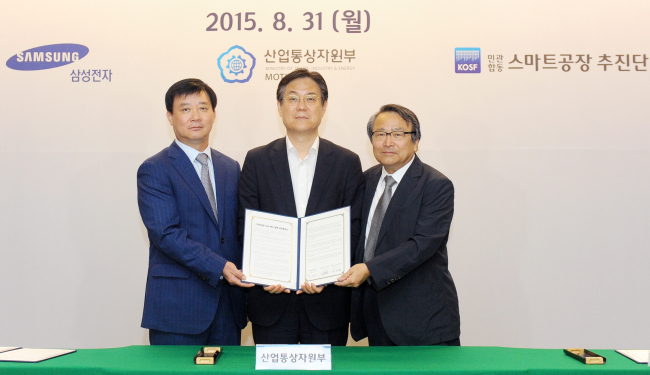 Samsung Electronic president Kim Jong-ho (left), Vice Industry Minister Lee Kwan-sup (center), and Park Jin-woo, the head of KOSF, a public-private institute to promote factory automation, pose at the memorandum of understanding signing ceremony in Seoul on Monday. (Samsung)