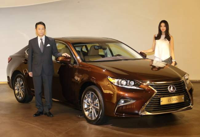 Lexus Korea CEO Akihisa Yoshida (left) poses with a model next to the all-new Lexus ES 300h during a launch event in Seoul on Tuesday. Lexus Korea