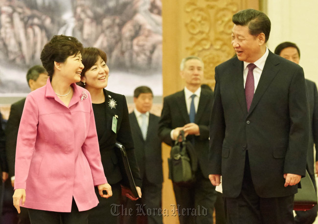 President Park Geun-hye (left) and her Chinese counterpart Xi Jinping chat before their lunch meeting in Bejing on Wednesday. (Yonhap)