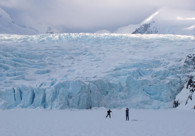 A skier poses for a photograph on Portage Lake in front of Portage Glacier, about 50 miles south of Anchorage, Alaska. (AP-Yonhap)