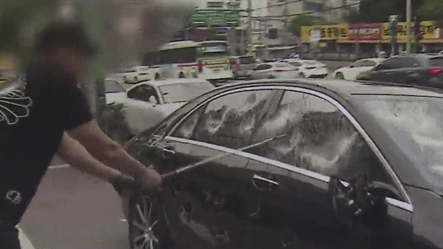 A captured image from a video of Yoo smashing his Mercedes-Benz car. YouTube