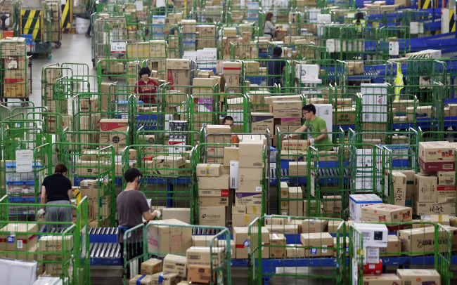 Workers sort out parcels at a warehouse in Osan, Gyeonggi Province, Friday, ahead of Chuseok next week. Yonhap